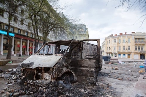 Burned car in the center of city after unrest - aragami12345s l Shutterstock.com