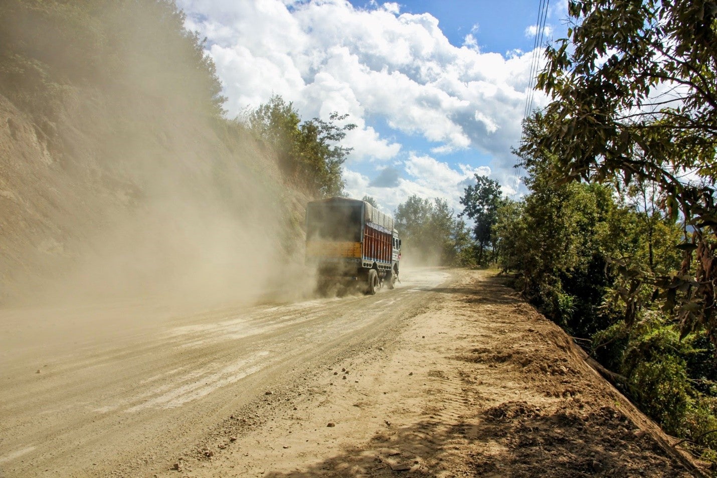 A truck moving on a dusty road in Northeast India. Photo: Srinivasan Balaji/ Shutterstock 