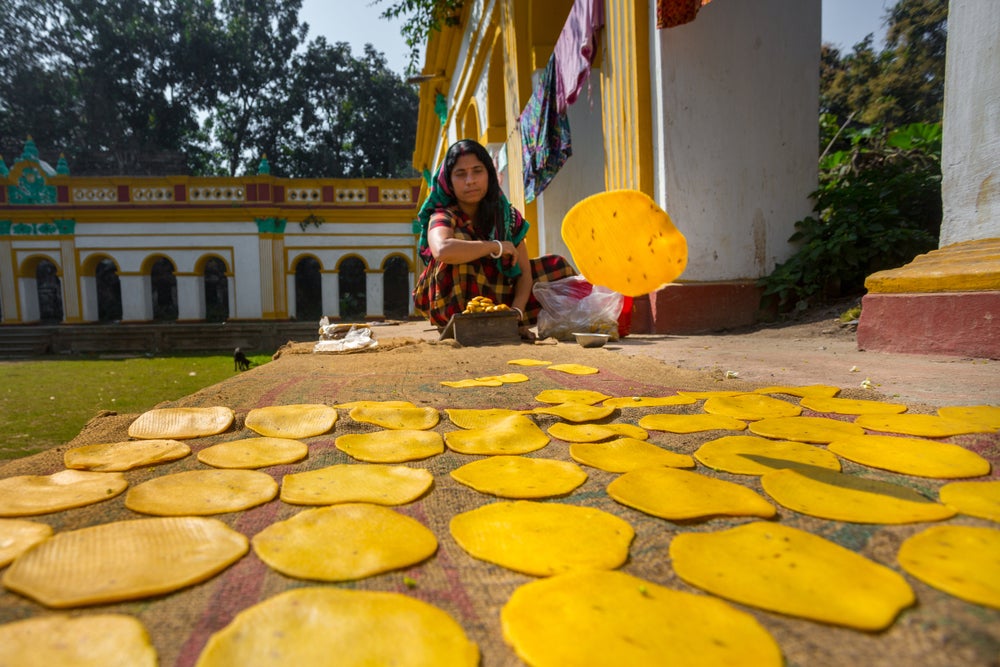 A small business woman making handmade Pappor (deep-fried bread) at Dinajpur Palace, Dinajpur, Bangladesh