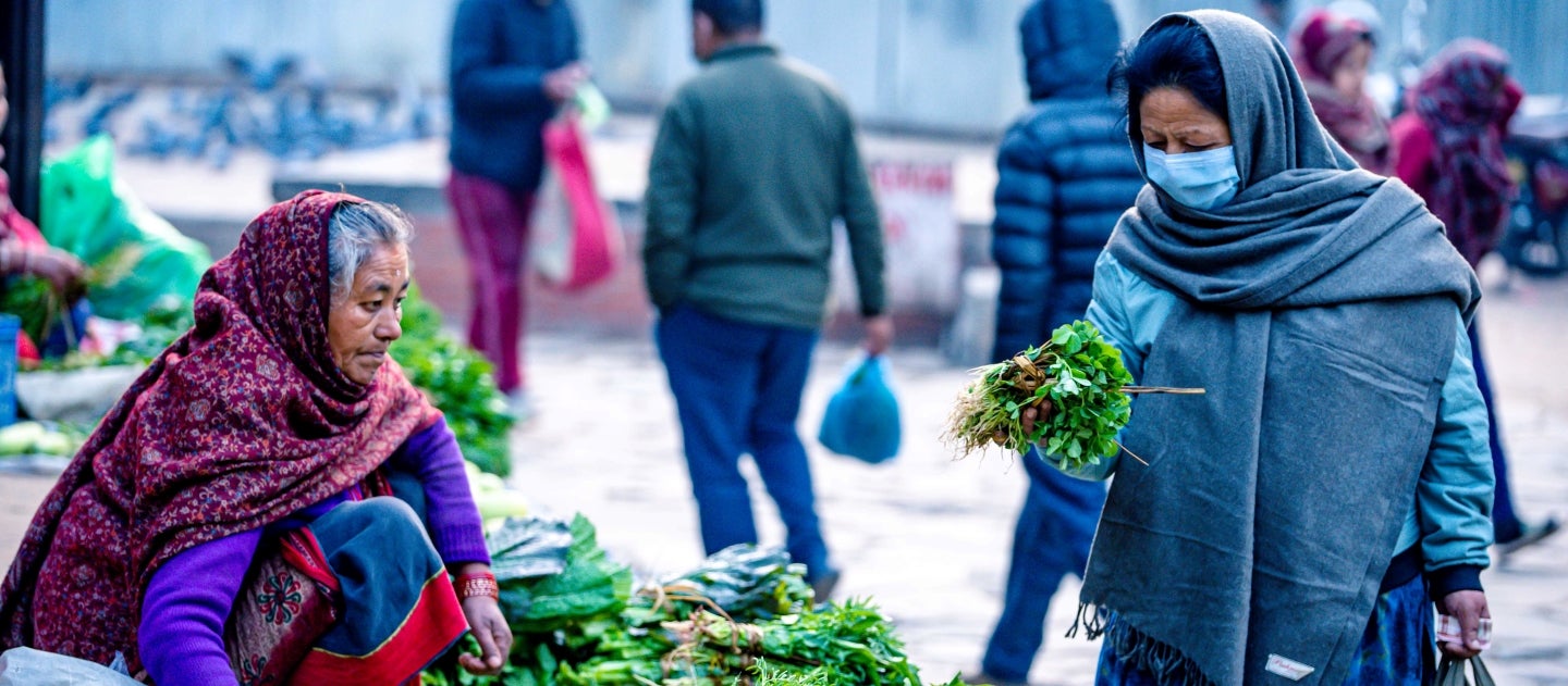 Women selling and buying vegetables in the street of Kathmandu Women selling and buying vegetables in the street of Kathmandu