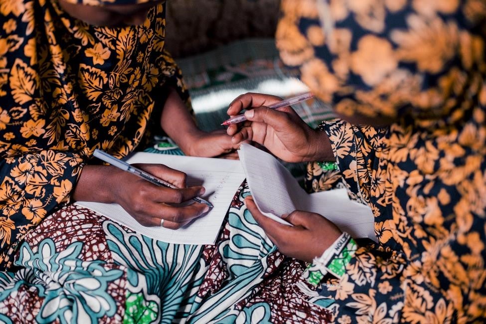 Meninas jovens na Níger fazendo os deveres de casa de matemática. Crédito fotográfico: Olivier Girard