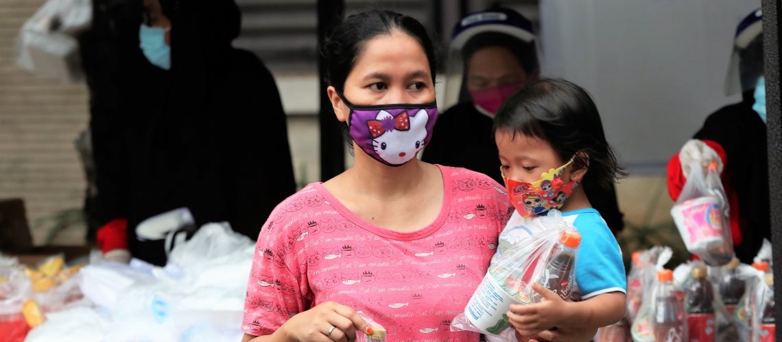 Une mère et sa fille reçoivent de l'aide alimentaire pendant la pandémie de COVID-19 à Jakarta (Indonésie). Photo : Achmad/Banque mondiale Une mère et sa fille reçoivent de l'aide alimentaire pendant la pandémie de COVID-19 à Jakarta (Indonésie). Photo : Achmad/Banque mondiale