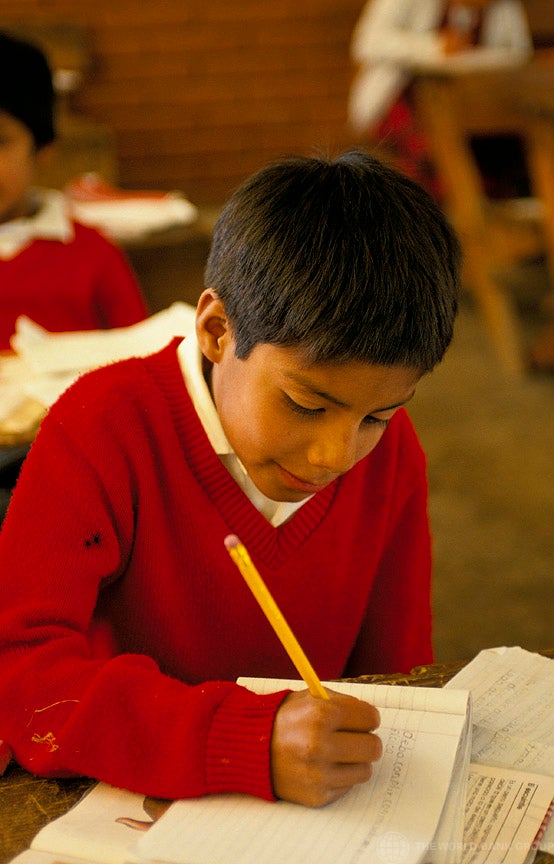 Niño escribiendo en escuela
