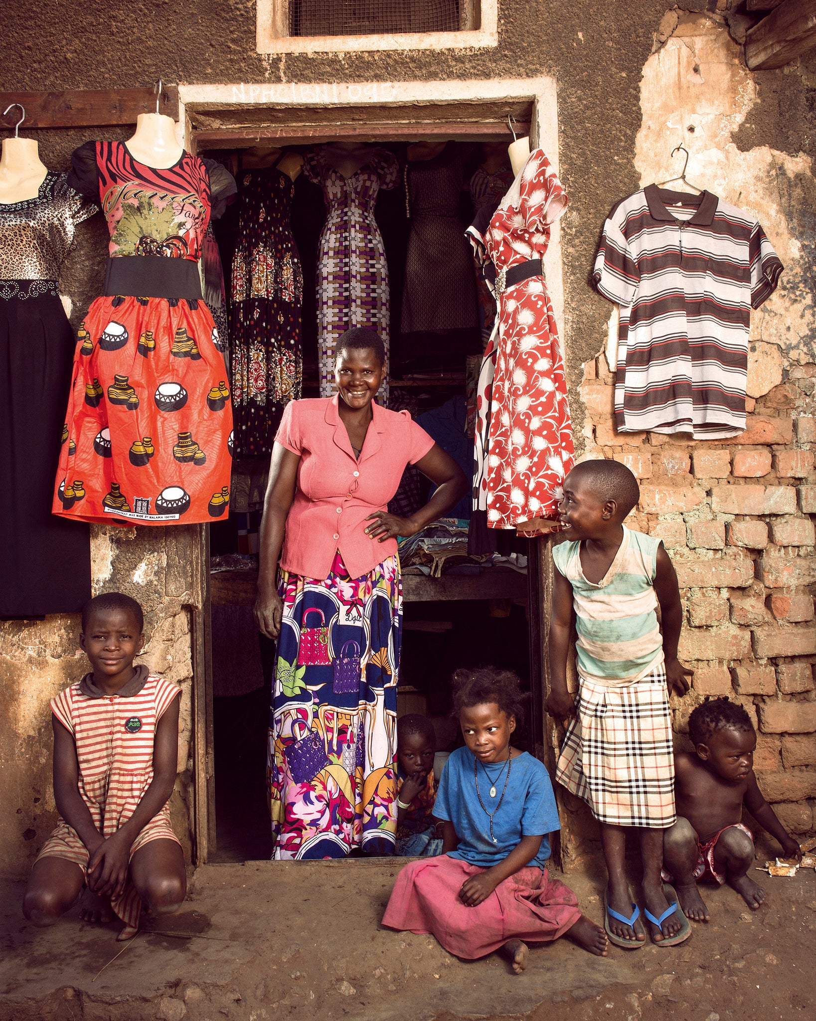 Florence Namatovu, 46, and five of her children fill the entrance to her shop in Mukoko village in central Uganda Image