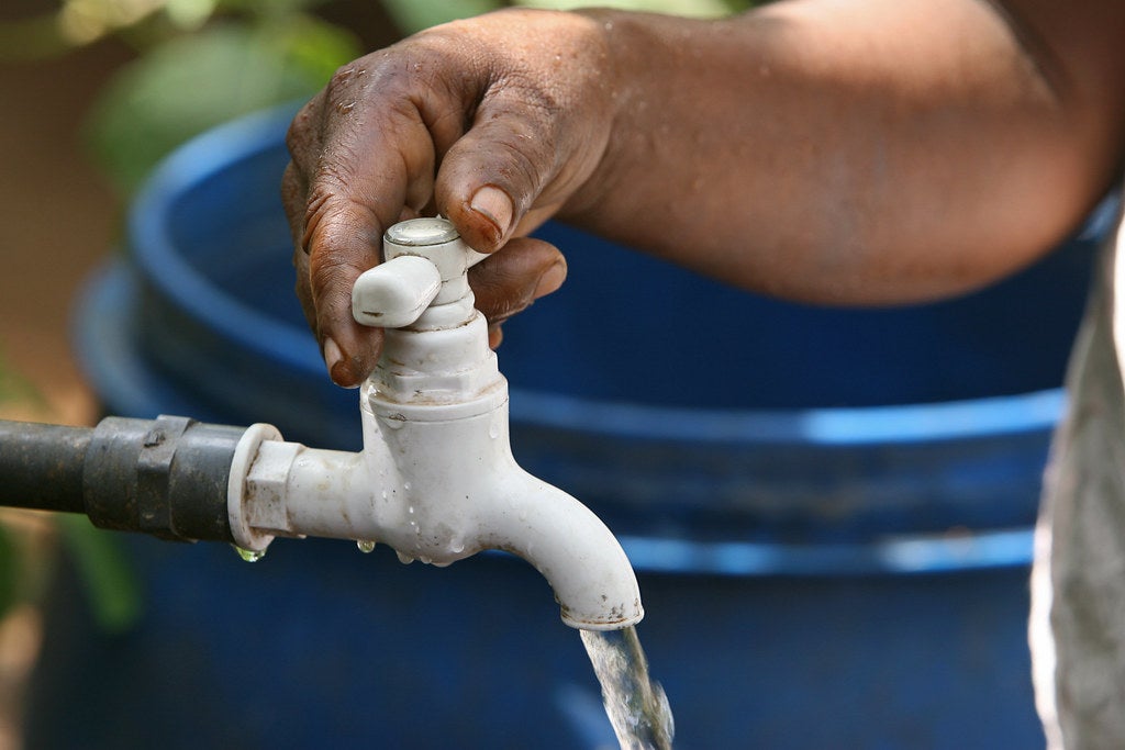 Woman turns on tap for clean water.