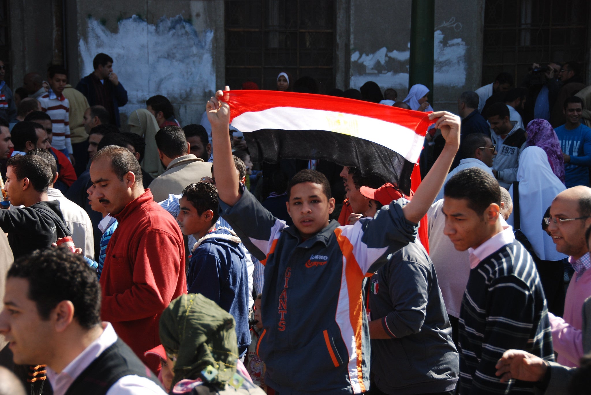 A young Egyptian protester holding an Egyptian flag, Cairo, Egypt A young Egyptian protester holding an Egyptian flag, Cairo, Egypt