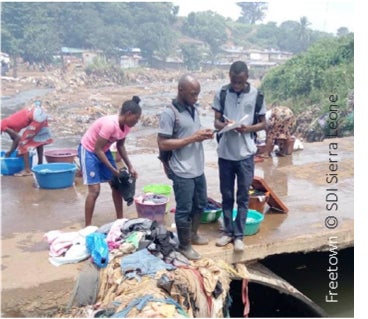 People in Freetown washing clothes by the river