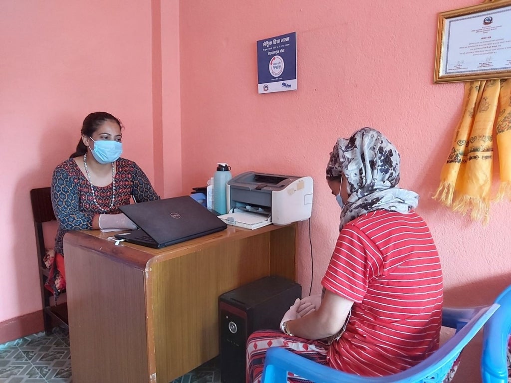 A woman counsels another woman in an office setting