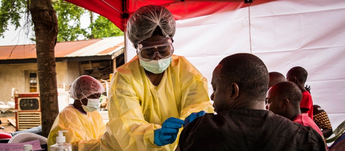 A health worker vaccinate a man who has been in contact with an Ebola affected person