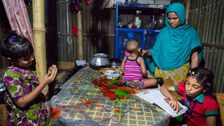 Sumaiya lee en su casa en el barrio marginal de Sujat Nagar en Bangladesh.