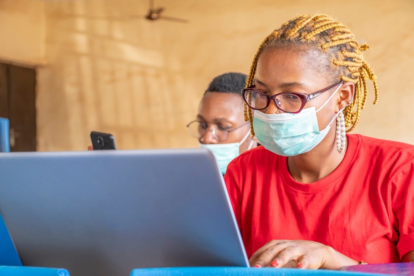 Deux étudiants africains utilisent leur ordinateur portable et leur téléphone au sein d'une classe | Photo : Shutterstock Deux étudiants africains utilisent leur ordinateur portable et leur téléphone au sein d'une classe | Photo : Shutterstock