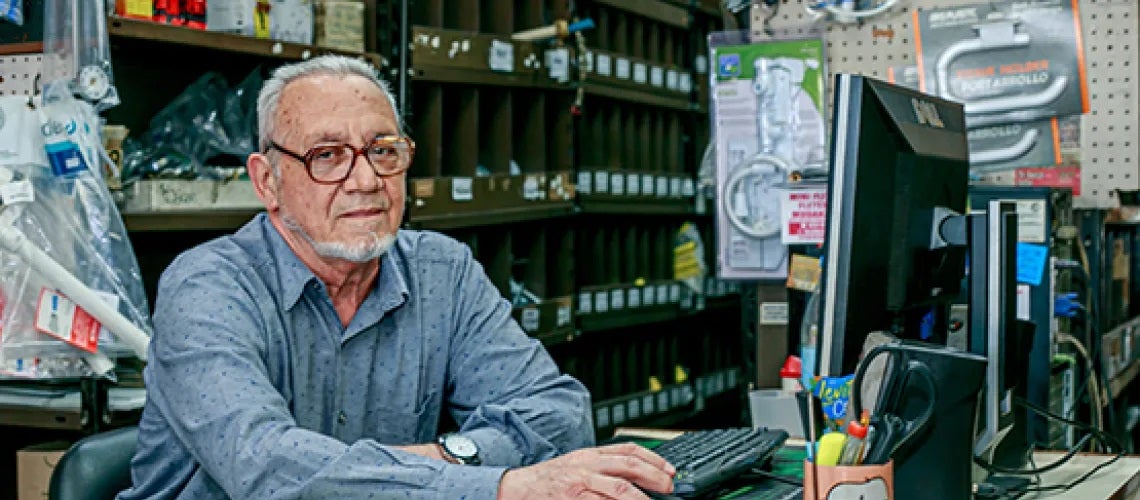 A man at his business, in front of a computer.