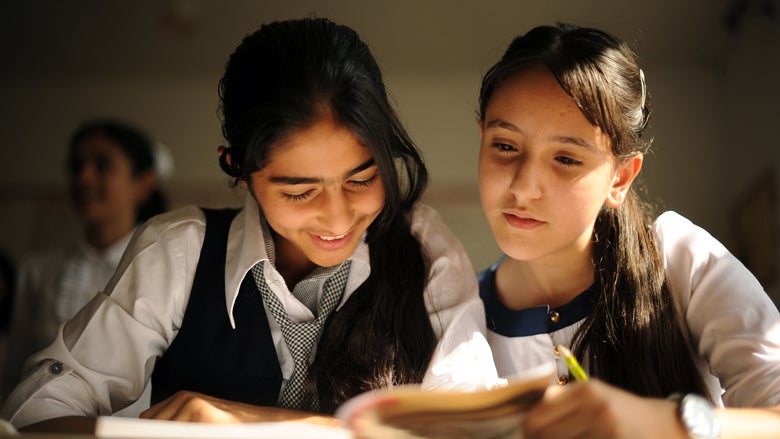 Two Azerbaijani girls reading a book