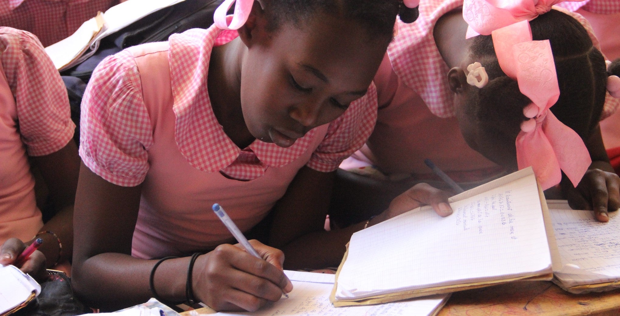 Haitian girl writing in a classroom in La Ruche Enchantee a Carrefour. Photo: World Bank 
