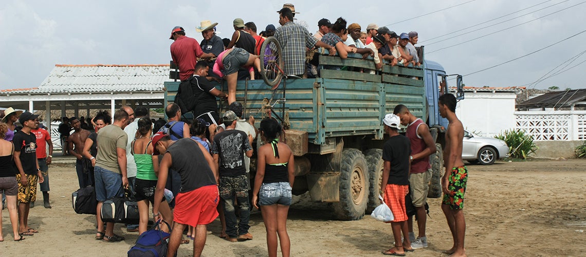 Central American migrants boarding a truck on their way to the United States