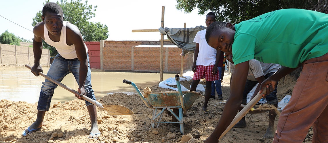 Young men cleaning up after the floods Young men cleaning up after the floods
