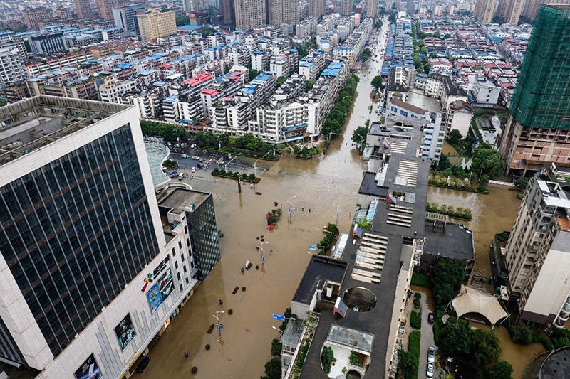 Jiangxi (China), 1 de julio de 2017: En China oriental, la ciudad de Jiujiang se vio afectada por intensas lluvias y muchas zonas urbanas resultaron inundadas. Los vehículos quedaron a merced de las aguas y los ciudadanos se abrían paso por los peligrosos caminos anegados. Jiangxi (China), 1 de julio de 2017: En China oriental, la ciudad de Jiujiang se vio afectada por intensas lluvias y muchas zonas urbanas resultaron inundadas. Los vehículos quedaron a merced de las aguas y los ciudadanos se abrían paso por los peligrosos caminos anegados.