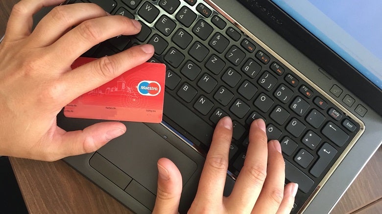 Hands holding credit card on a keyboard shopping online