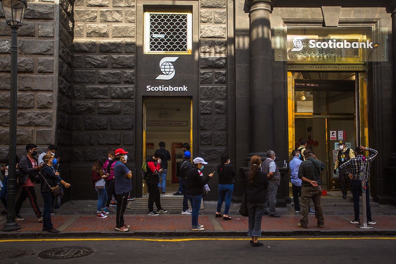 Long queue of people waiting to get into a bank branch 