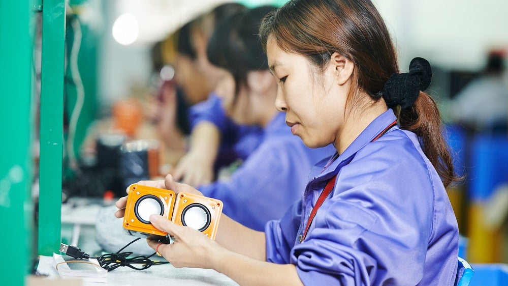 A Chinese worker assembling production at line conveyor in China factory A Chinese worker assembling production at line conveyor in China factory