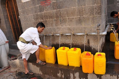 A man fills bottles with water in Sanaía, Yemen. © Foad Al Harazi/World Bank