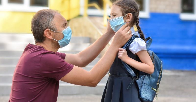 A photo of a father saying goodbye to his child by the school gate. A photo of a father saying goodbye to his child by the school gate.