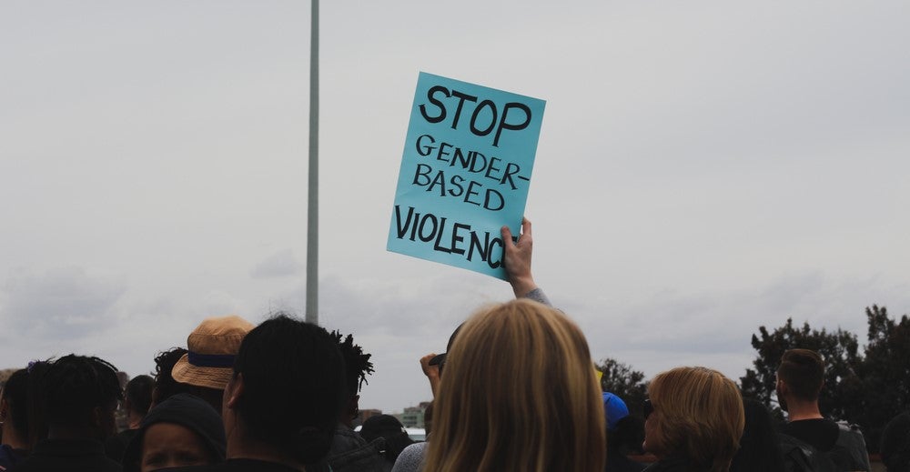 A protester holds up a sign at a demonstration against sexual violence. A protester holds up a sign at a demonstration against sexual violence.