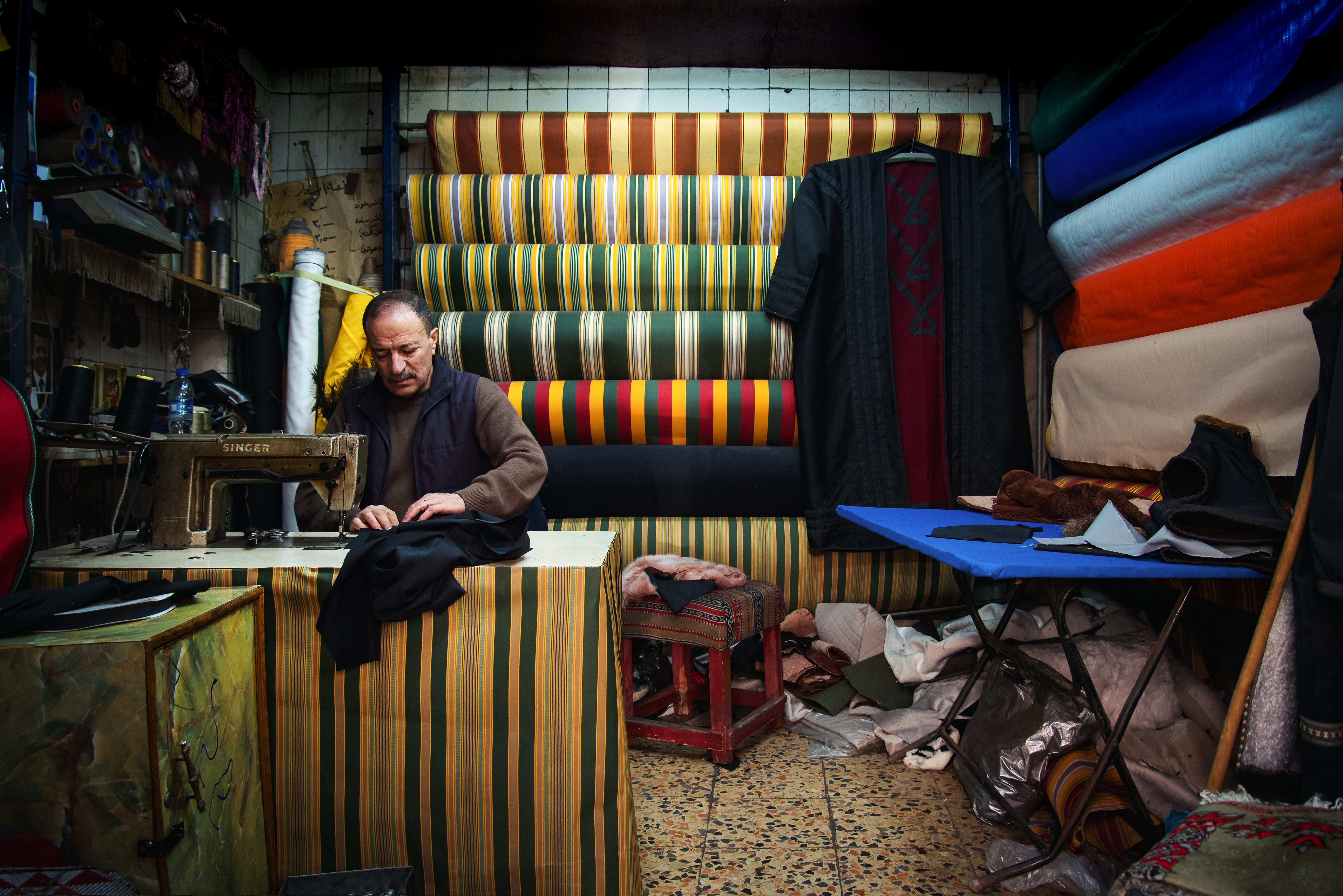 Man in textile shop in Jordan. (Seersa Abaza/ Shutterstock.com)