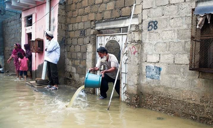 Citizens of Karachi paling water out of their homes during city flooding