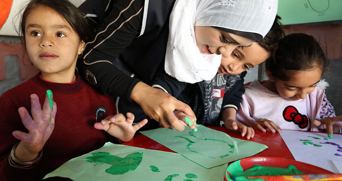 Niños refugiados sirios aprenden a pintar con los dedos. Niños refugiados sirios aprenden a pintar con los dedos.
