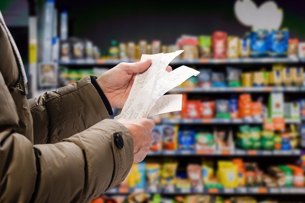 Man looking at receipt in grocery store. (Photo: Denys Kurbatov/Shutterstock.com)