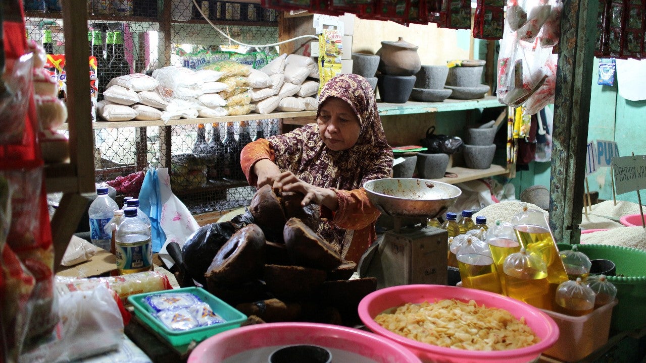An Indonesian lady is preparing to sell household items in a traditional market. Photo: Jerry Kurniawan/World Bank