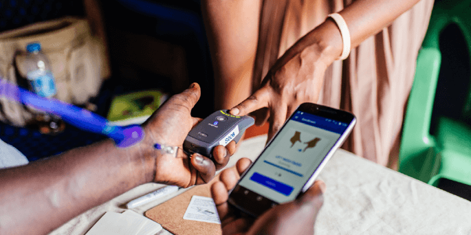 A woman uses her finger to get identified at a government service center