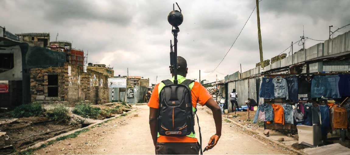 A worker walks through his settlement with a 360-degree terrestrial camera to capture Street View images. Photo: Spatial Collective