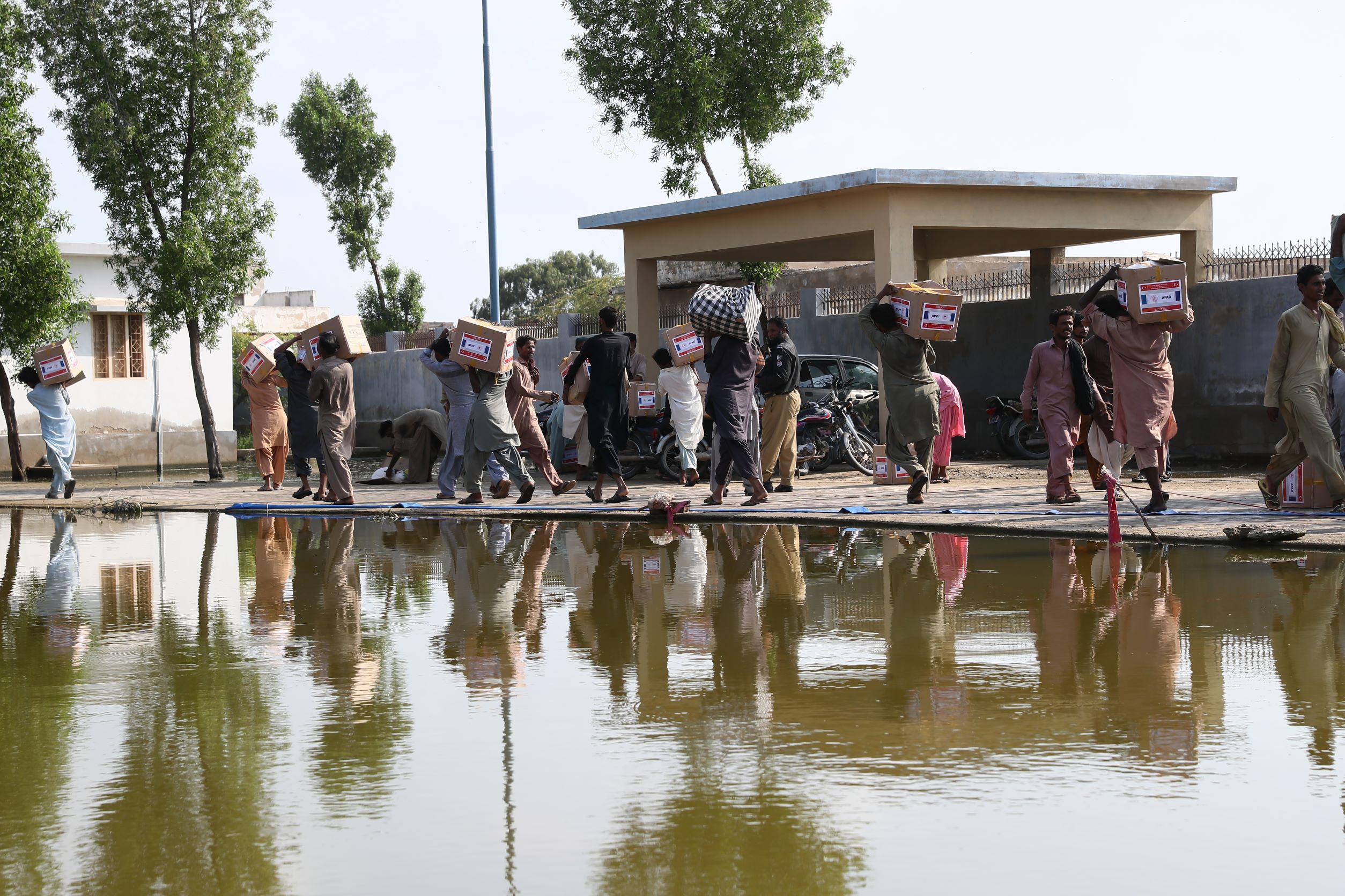 Picture of people collecting aid in flooded Mirpur Khas city, Pakistan. 