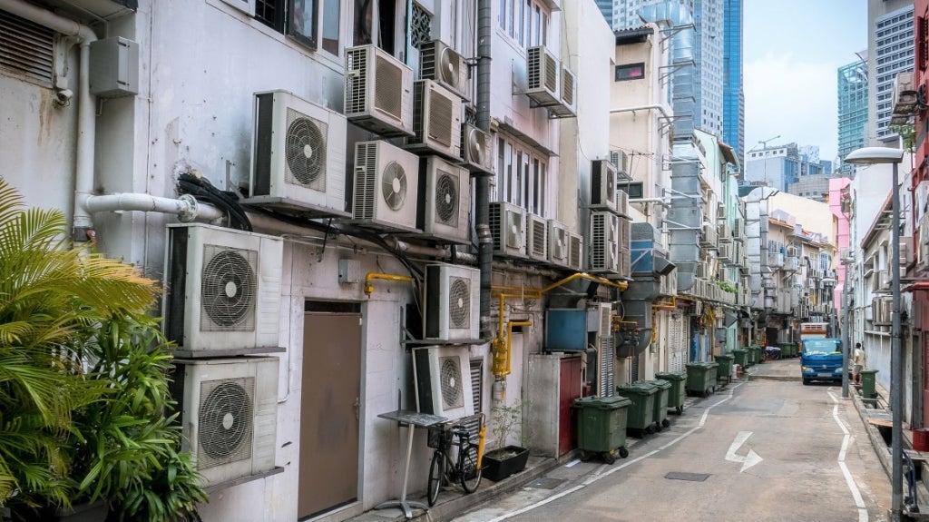 Air Conditioning units crowd the rear wall of a Singapore street. Photo: N8Allen/Shutterstock