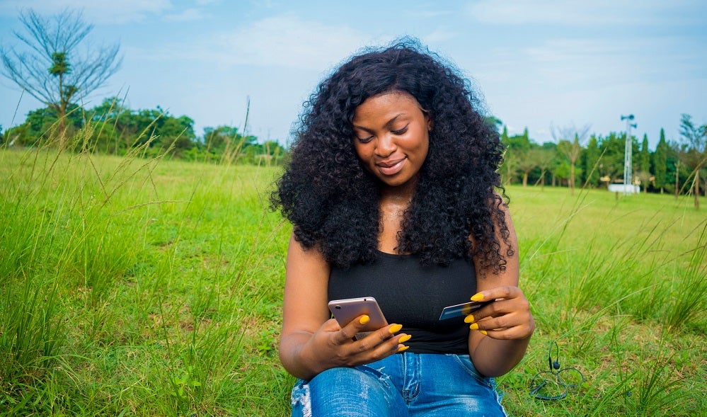 Nigerian woman using mobile phone to make financial transaction