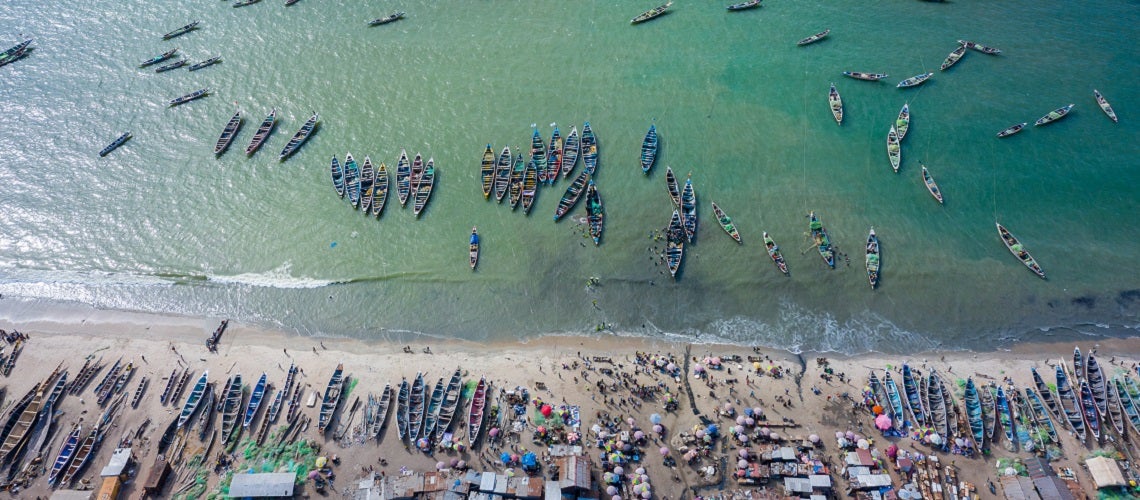 Aerial view of unloading of fishing boats in the fishing village of Tanji, The Gambia, West Africa.