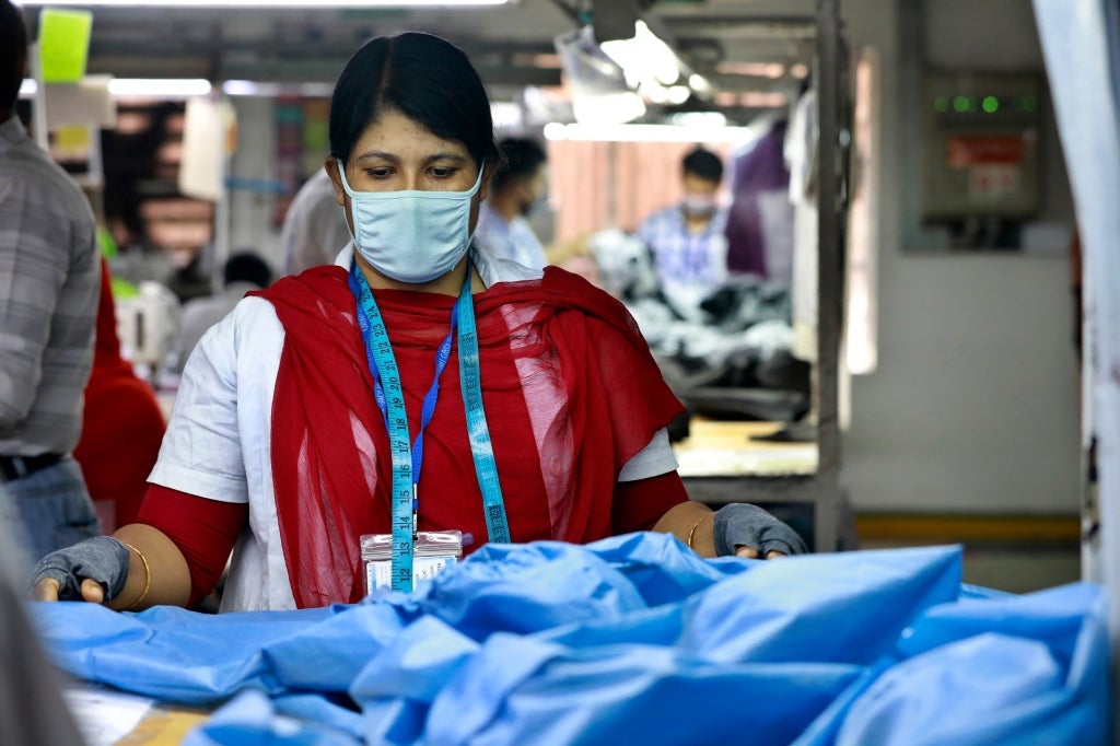 Workers producing personal protective equipment (PPE) for health professionals at a garment factory of Urmi Group in Dhaka, Bangladesh