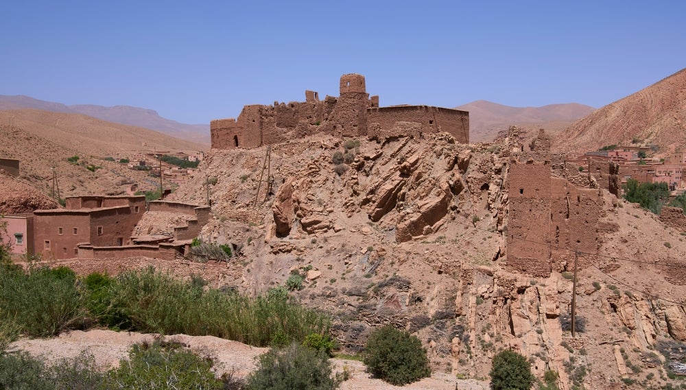 أنقاض قصبة تقف بين المنازل السكنية في قرية حديثة بجبال الأطلس بالمغرب بسبب زلزال 8 سبتمبر 2023