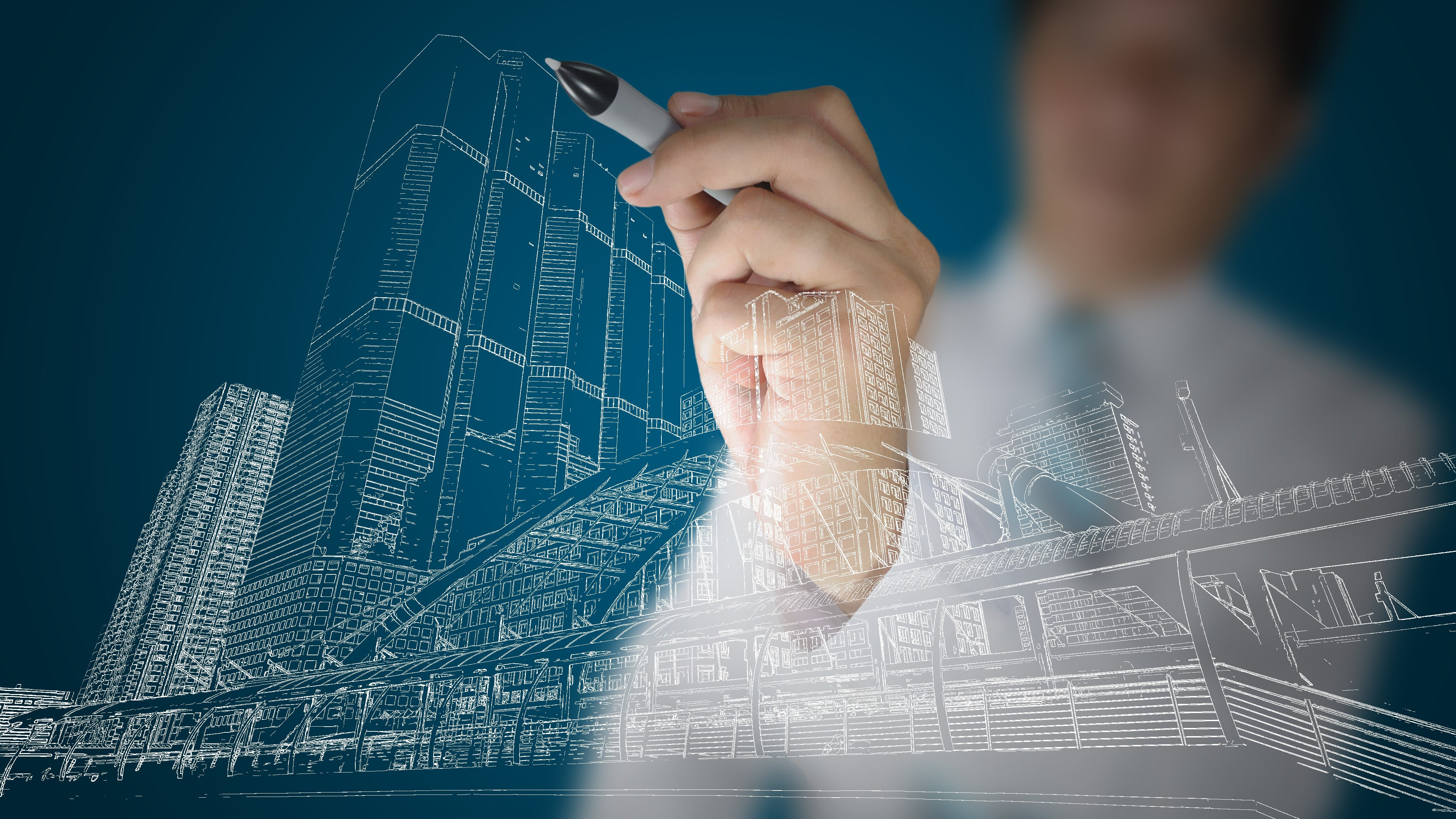 Business man draw building and cityscape | Photo credit: Thampapon, Shutterstock