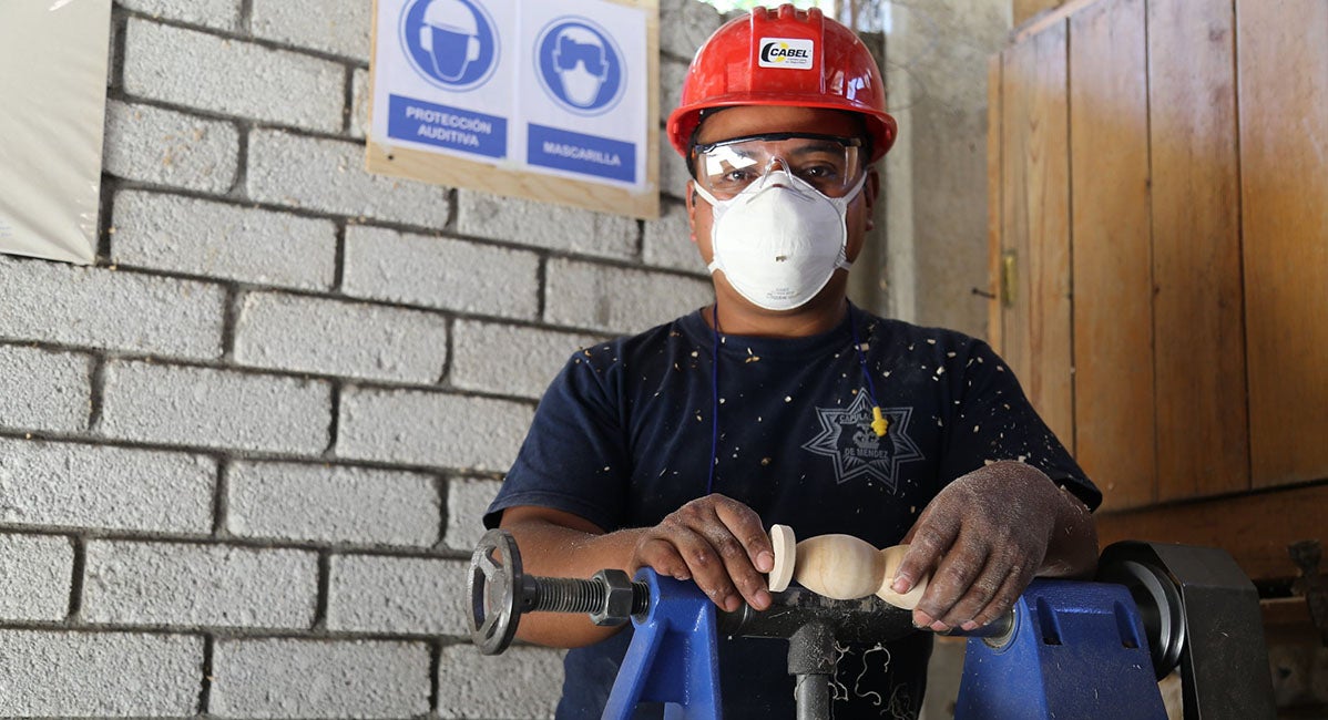 A worker looking at the camera wearing protective head gear