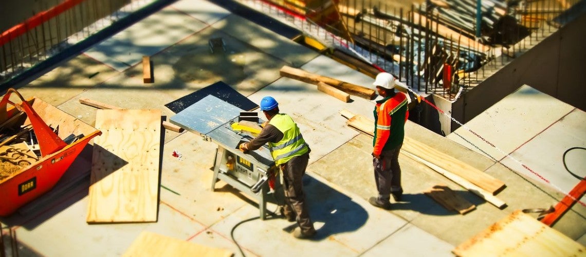 Two engineers figure out how to build a roof for a construction project in India Two engineers figure out how to build a roof for a construction project in India
