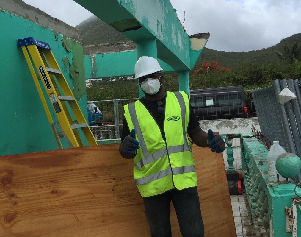 A worker repairing a damaged house in Sint Maarten