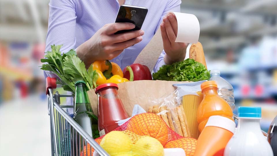 Image of a woman checking her groceries against her receipt.