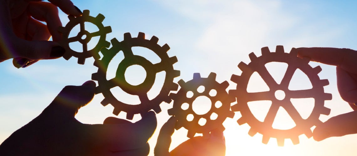 Four hands of businessmen collect gear from the gears of the details of puzzles. against the background of sunlight. The concept of a business idea. Teamwork. strategy. cooperation Four hands of businessmen collect gear from the gears of the details of puzzles. against the background of sunlight. The concept of a business idea. Teamwork. strategy. cooperation