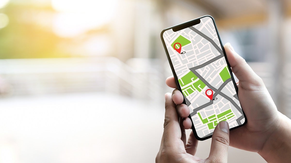 Traveler using navigation app on smartphone. Photo: onephoto/Adobe Stock