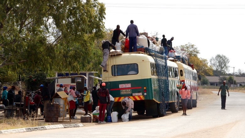 Travelers in Zimbabwe boarding a bus.